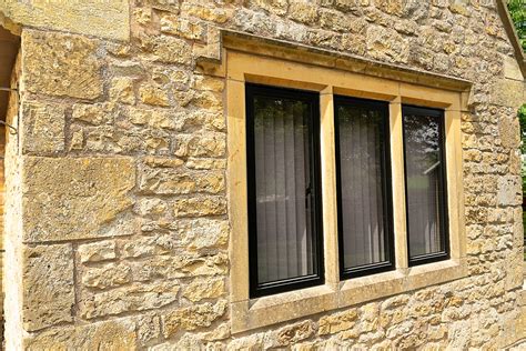 windows on a historic stone house porch with metal mullins|historic house window replacement.